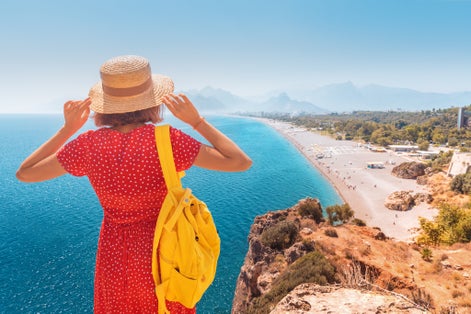 Photo of tourist looking from the height of the observation viewpoint overlooking Konyaalti beach in Antalya, Turkey.