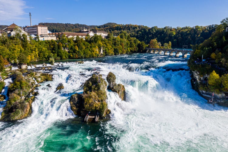 Rhine Falls, Rheinfall, Switzerland panoramic aerial view. Tourist boat in waterfall. Bridge and border between the cantons Schaffhausen and Zurich. Cliff-top Schloss Laufen castle, Laufen-Uhwiesen.