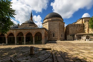 Touristic sightseeing ships in Golden Horn bay of Istanbul and mosque with Sultanahmet district against blue sky and clouds. Istanbul, Turkey during sunny summer day.