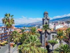 Photo of aerial view with Puerto de la Cruz, in background Teide volcano, Tenerife island, Spain.