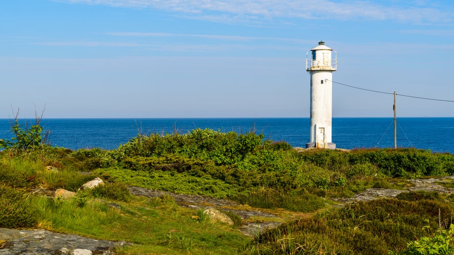 photo of The Subbe lighthouse in southern Varberg, Sweden, with surrounding landscape on a sunny and calm morning.