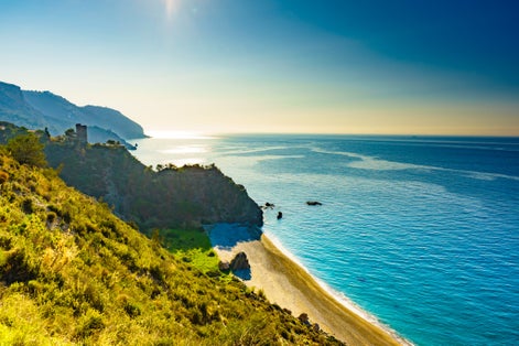 Photo of coast view with watchtower. Torre Del Pino, Pine tower on cliffs of Maro Cerro Gordo Natural Park, Malaga province.