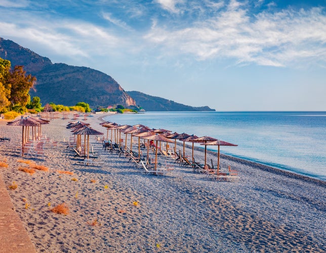 Photo of stunning morning seascape of beautiful Plaka beach with sunbeds and umbrellas in Naxos Island, Cyclades, Greece.