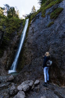 Woman taking photo of waterfall siklawica,Poland.