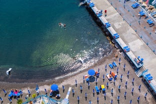 photo of aerial panorama of high cliffs, Tyrrhenian Sea Bay with pure azure water, floating boats and ships, pebble beaches, rocky surroundings of Meta in Sant'Agnello and Sorrento cities near Naples region in Italy.