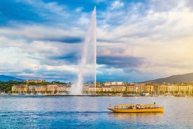 Geneva skyline cityscape, French-Swiss in Switzerland. Aerial view of Jet d'eau fountain, Lake Leman, bay and harbor from the bell tower of Saint-Pierre Cathedral. Sunny day blue sky.