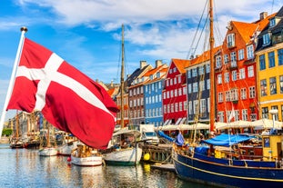 Scenic summer view of Nyhavn pier with color buildings, ships, yachts and other boats in the Old Town of Copenhagen, Denmark