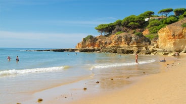 Photo of wide sandy beach in white city of Albufeira, Algarve, Portugal.