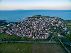 Photo of Saint Anastasia Island in Burgas bay, Black Sea, Bulgaria. Lighthouse tower and old wooden buildings on rocky coast.