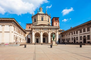 Photo of Italy Piazza Maggiore in Bologna old town tower of town hall with big clock and blue sky on background, antique buildings terracotta galleries.