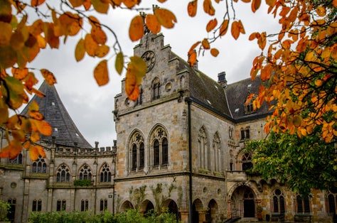 Bentheim Castle (Burg Bentheim), an early medieval hill castle in Bad Bentheim, Lower Saxony, Germany. Around castle a lot of autumn trees and green grass.