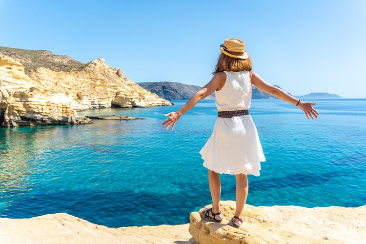 Photo of tourist woman looking at the sea in Rodalquilar in Cabo de Gata on a beautiful summer day, Almería.