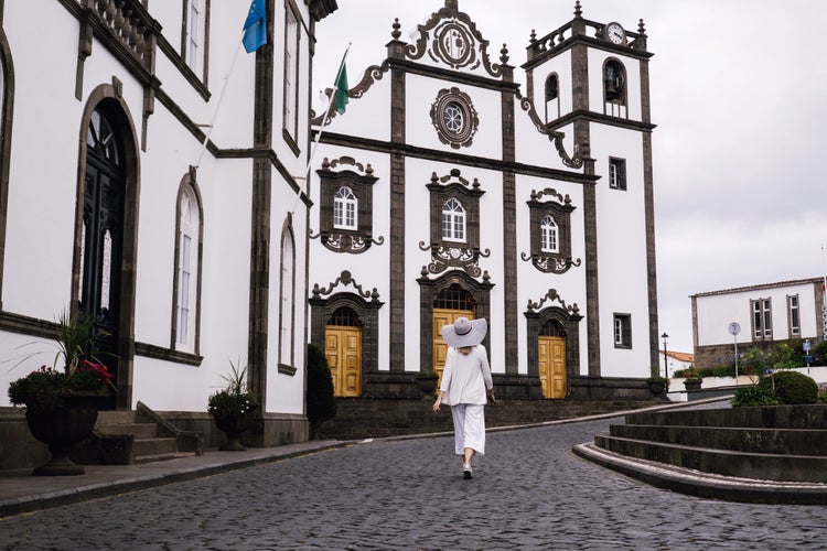 Photo of woman traveling in Azores island walking in city with white buildings, Ponta Delgada ,Portugal.