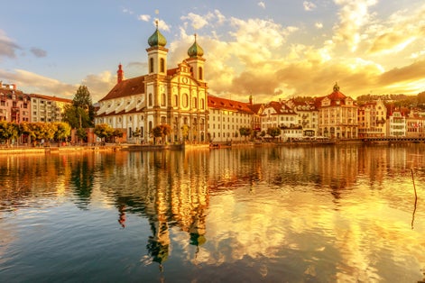 photo of amazing colorful sunset Jesuit Church of St. Francis Xavier reflects on Reuss river in Lucerne , Switzerland.