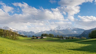 photo of Elevated, scenic view of the town of Bischofswiesen, Bavaria, Germany. The Watzmann Mountain, part of the Bavarian Alps rises into a majestic skyline. A green, spring landscape set in the valley.