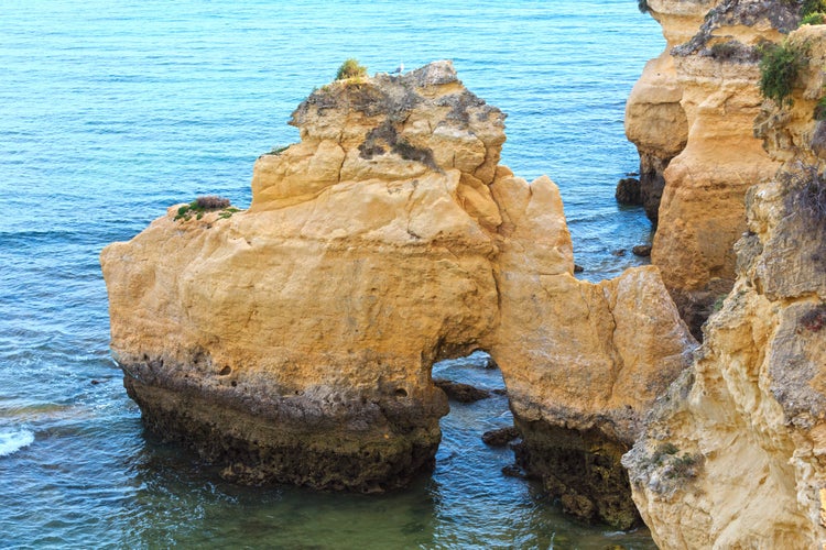 Photo of summer Atlantic ocean coast view with rock formations (Porches, Lagoa, Algarve, Portugal).