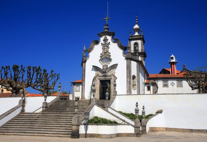 Portugal, Minho Region, Viana do Castelo, the Chapel of Our Lady of Sorrows - Nossa Senhora da Agonia. A beautiful 18th century granite and whitewash baroque church. Unusual lighthouse in background.