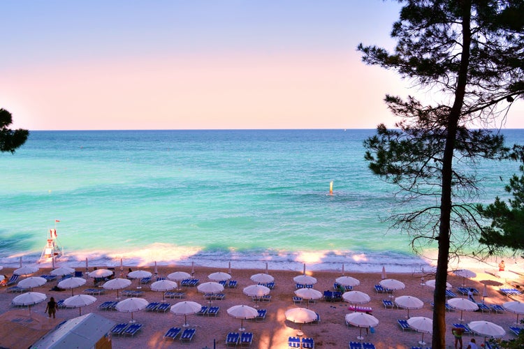 Photo of landscape of the San Michele beach with sunbeds and beautiful water and the Sassi Neri in Sirolo, Italy.