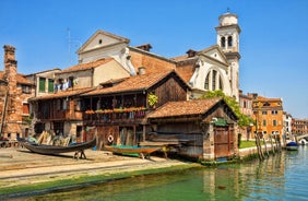 Famous buildings, gondolas and monuments by the Rialto Bridge of Venice on the Grand Canal, Italy.