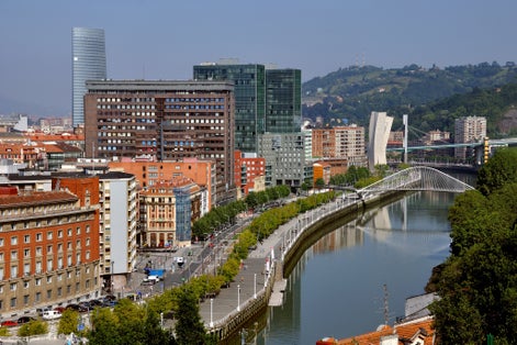Photo of Aerial view of Bilbao, Spain city downtown with a Nevion River, Zubizuri Bridge and promenade. It is a capital of province of Biscay, a very large city and a popular touristic destination.