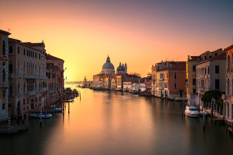 photo of Beautiful view of traditional Gondola on Canal Grande with Basilica di Santa Maria della Salute in the background on a sunny day in Venice, Italy .