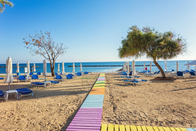 Photo of beautiful beach and palm trees, sunny day in the resort of Paphos, Cyprus.