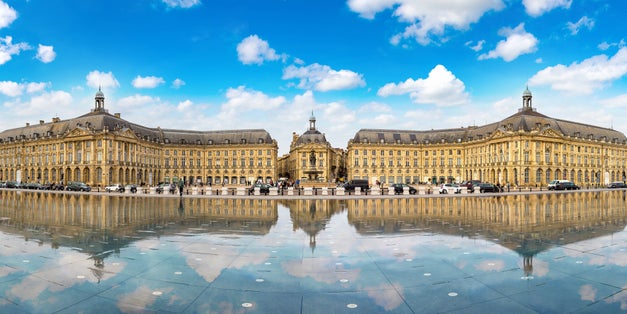 photo of the water mirror in front of the Place de la Bourse in Bordeaux in a beautiful summer morning in France.