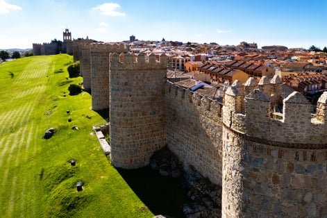 Photo of Drone point of view The Walls of Avila and cityscape rooftops, view against blue sky during sunny day. Famous fortification, spanish landmark in Castile and Leon, UNESCO,Spain