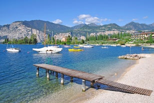 Photo of aerial view of superb Malcesine Mediterranean cityscape with colorful buildings and boats, yachts in the bay, lake Garda, Italy.