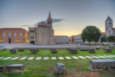Vista del amanecer de la plaza Zeleni trg en Zadar con la iglesia de Saint Donatus, la iglesia de Santa Marija y el museo arqueológico