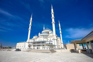 Touristic sightseeing ships in Golden Horn bay of Istanbul and mosque with Sultanahmet district against blue sky and clouds. Istanbul, Turkey during sunny summer day.