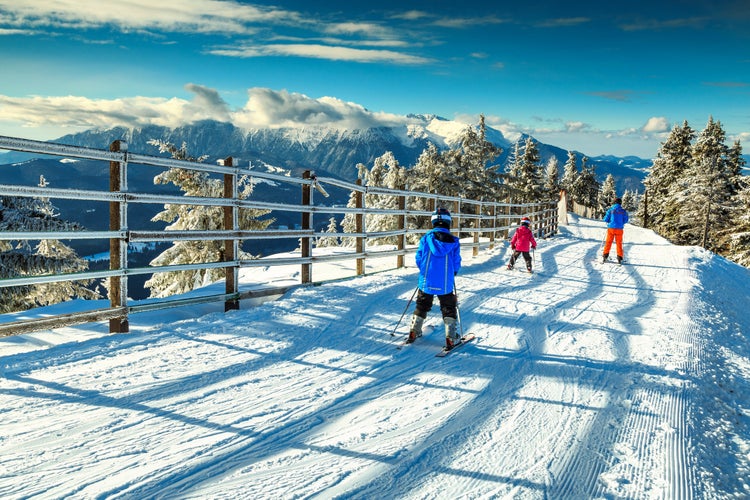 Stunning winter landscape with wonderful Bucegi mountains in background and skiers on the ski slopes,Poiana Brasov ski resort,Transylvania,Romania,Europe