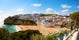 Photo of beautiful aerial view of the sandy beach surrounded by typical white houses in a sunny spring day, Carvoeiro, Lagoa, Algarve, Portugal.