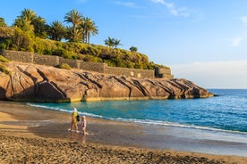 photo of aerial shot of Costa Adeje area, South Tenerife, Spain. Captured at golden hour, warm and vivid sunset colors. Luxury hotels, villas and restaurants behind the beach.