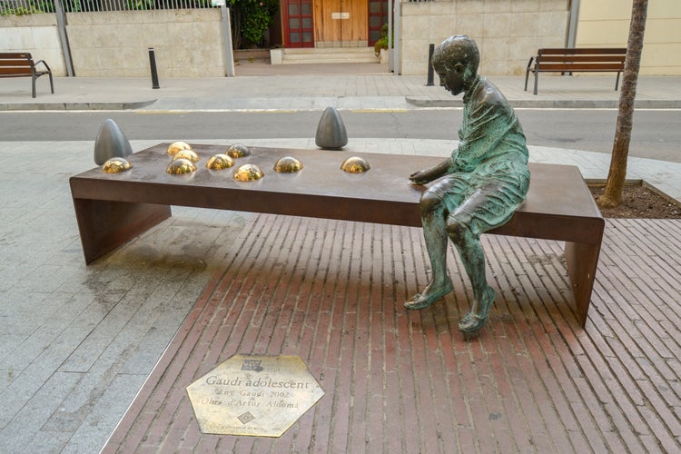 Reus, Tarragona / Spain - Street statue of the adolescent Gaudí playing marbles. Reus is the hometown of the famous Catalan architect Antoni Gaudí.