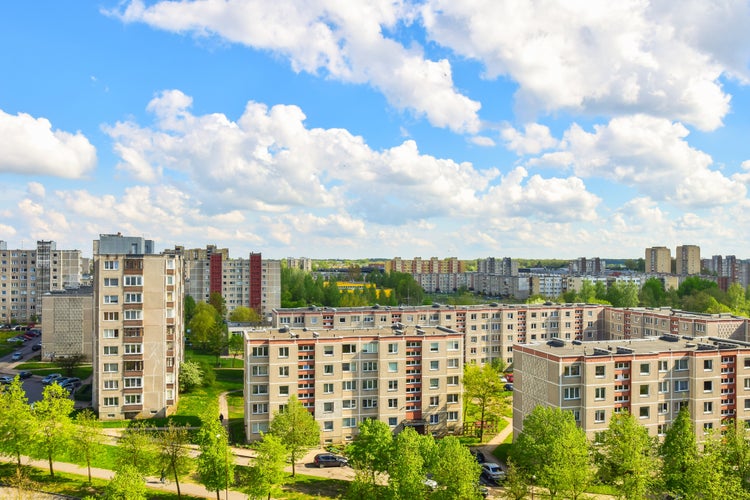 Aerial panoramic view of the southern part of Siauliai city in Lithuania.Old soviet union buildings with green nature around and yards full of cars in a sunny day.