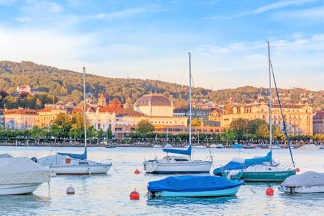 Photo of Lake Zurich with boats and Opera House in background, Switzerland.