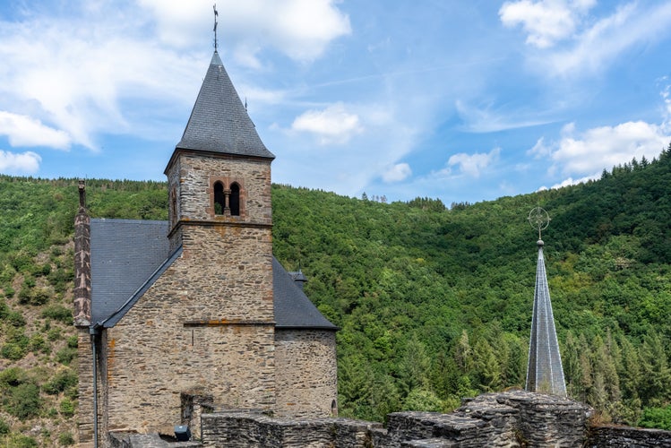 Small town Esch-sur-Sure in Luxembourg. The Bell Tower of old stone church. The view of ancient church. Old Romanesque architecture. Gothic style of Medieval Europe.