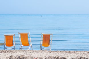 Photo of beach chairs, on a sandy, shoreline, in Giulianova, Italy.