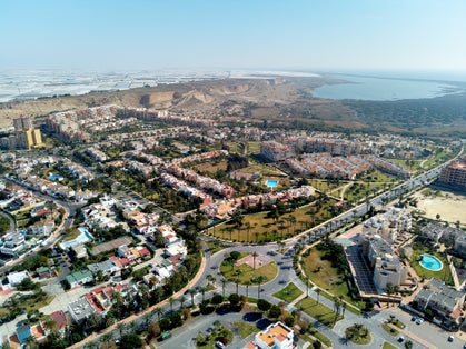 Aerial wide drone point of view photography Almerimar townscape with residential houses streets and roads, lot of greenhouses Victoria lake. El Ejido municipality in Almeria province. Andalucia, Spain
