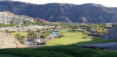 photo of landscape with Maspalomas town and golden sand dunes at sunrise, Gran Canaria, Canary Islands, Spain.