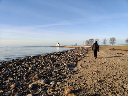 photo of a man walking on the Nallikari beach in Oulu, Finland.