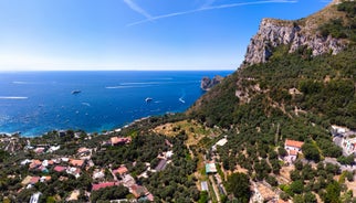 Photo of aerial view Nerano village, Infrastructure of a small town in the south of Italy, old houses, tight construction, mountain and sea in the background.