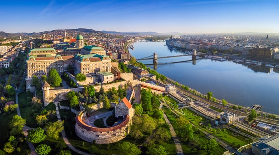 Photo of aerial panoramic skyline view of Buda Castle Royal Palace with Szechenyi Chain Bridge, St.Stephen's Basilica, Hungarian Parliament and Matthias Church at sunrise with blue sky, Budapest, Hungary.