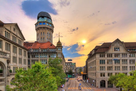 photo of beautiful cityscape looking towards the Urania Sternwarte observatory telescope in Zurich, Switzerland, with a beautiful sunset sky in summer.