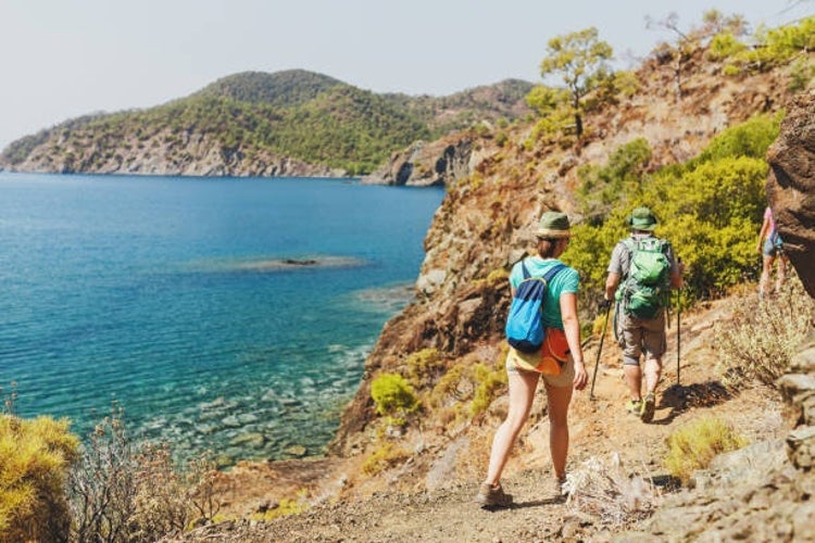 Hikers walking by the Lycian Way trail along wild beach and mountains.jpg