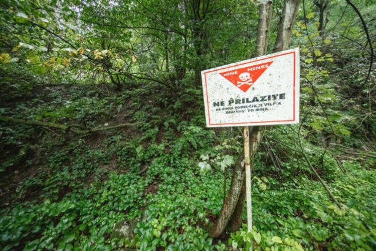 A Do Not Enter sign in a forest in Bosnia and Herzegovina, warning of the danger of land mines in the area.jpg