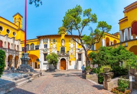 Photo of Old harbour Porto Vecchio with motor boats on turquoise water, green trees and traditional buildings in historical centre of Desenzano del Garda town, Northern Italy.