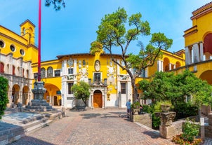 Photo of Old harbour Porto Vecchio with motor boats on turquoise water, green trees and traditional buildings in historical centre of Desenzano del Garda town, Northern Italy.