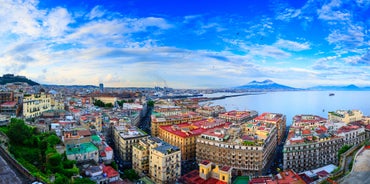 Naples, Italy. View of the Gulf of Naples from the Posillipo hill with Mount Vesuvius far in the background and some pine trees in foreground.